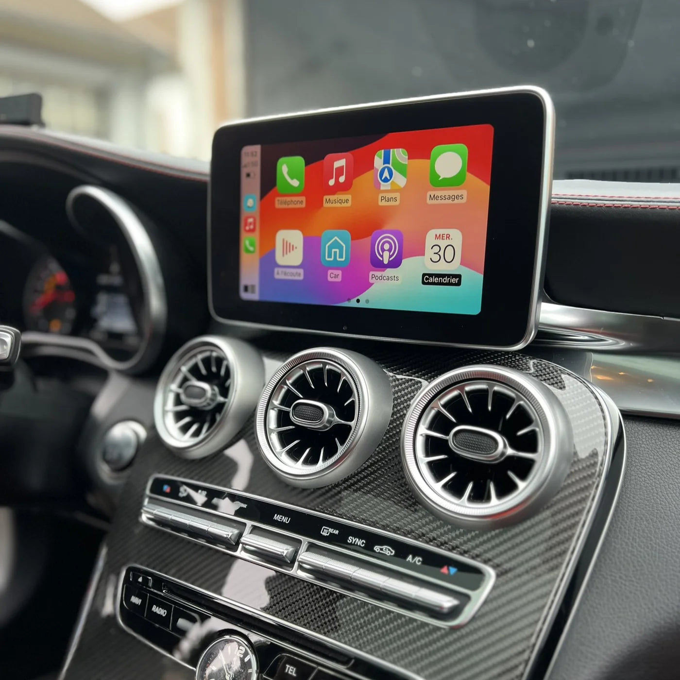 Écran multimédia Apple Carplay Mercedes affichant les applications principales dans une voiture de luxe